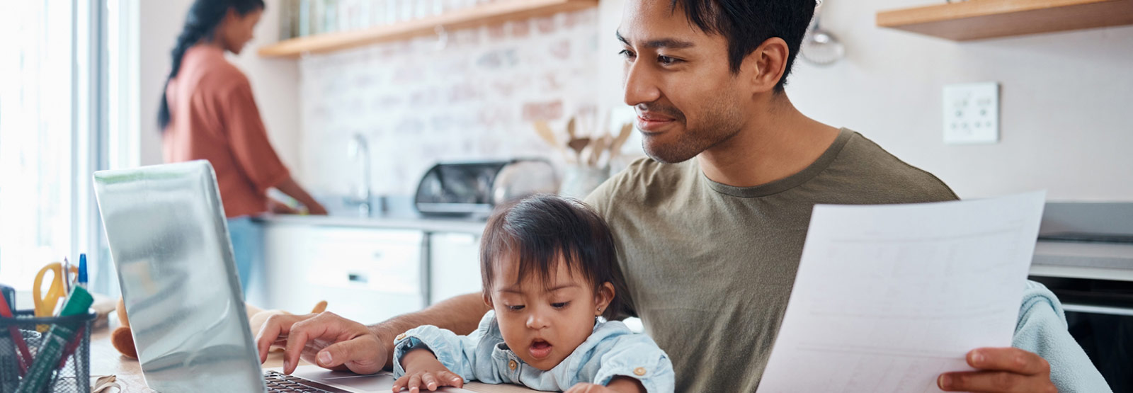 Parent with child using laptop to bank.